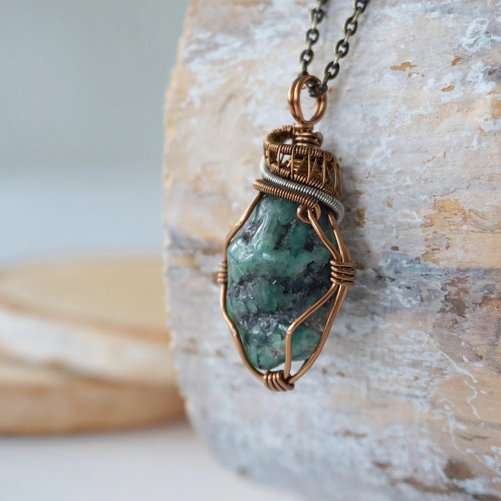 Left angle close-up of emerald necklace – highlighting unique wire-wrapped artistry, raw emerald crystal, gender-inclusive jewelry.