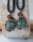 Two raw emerald pendants for men – unique differences in natural emerald crystals, wire-wrapped, black leather cord.