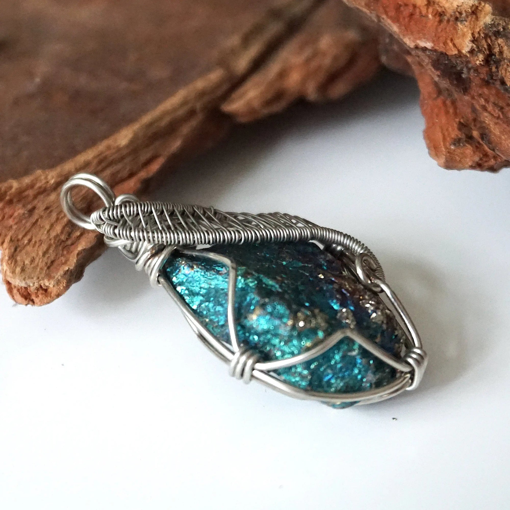 Right angle close-up of peacock ore pendant for men – showcasing artisan wire wrapped white gold copper, natural bornite crystal.