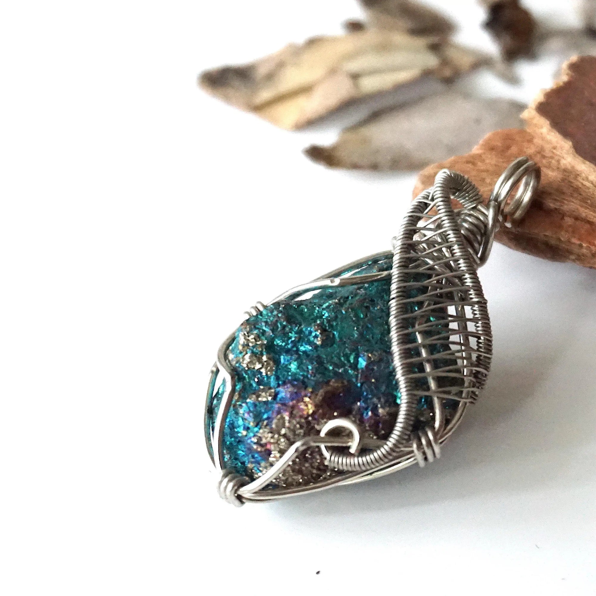 Left angle close-up of peacock ore pendant for women – highlighting unique wire-wrapped artistry, white gold copper, Capricorn and Cancer birthstone.