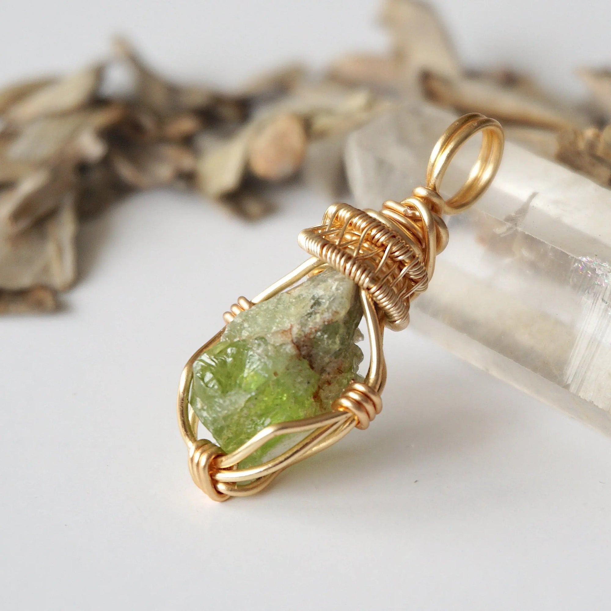 Left angle detail of raw peridot necklace for women – close-up of wire wrapping and vivid green peridot.