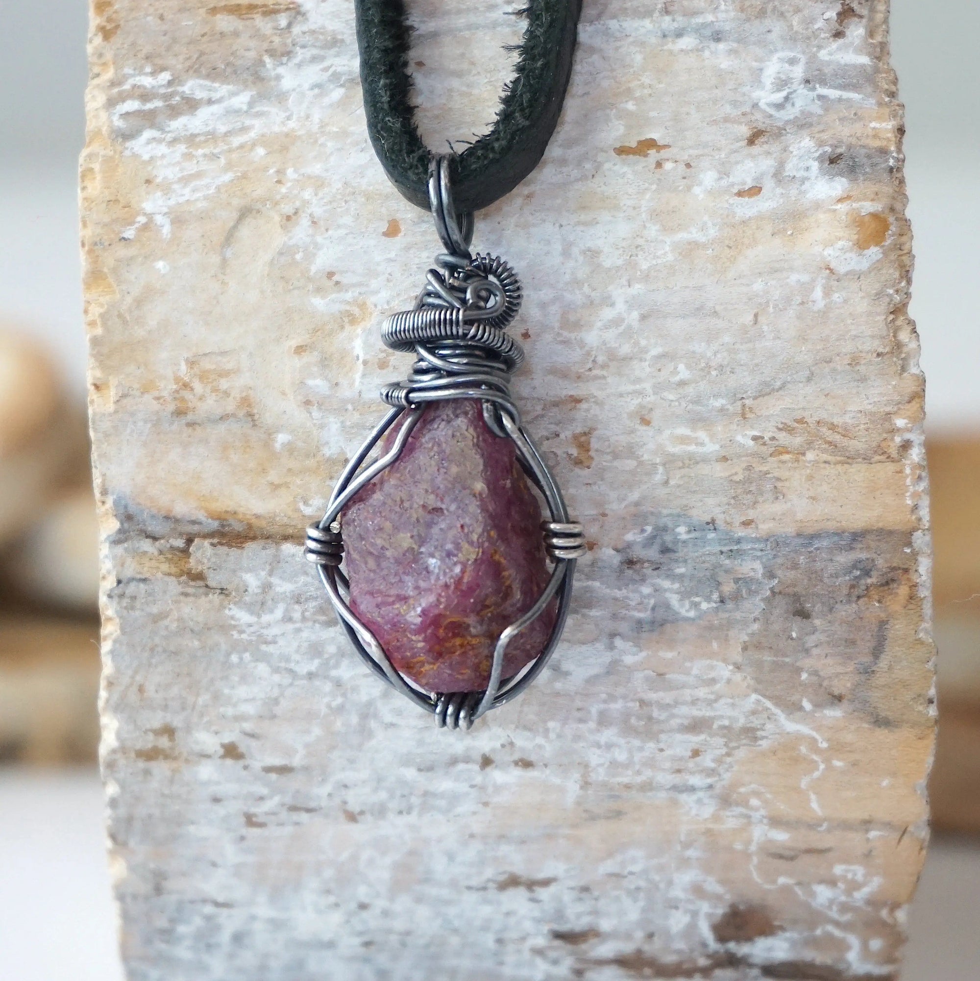 Back view of handcrafted men's ruby necklace – natural stone and wire wrapping, July birthstone, black leather cord.