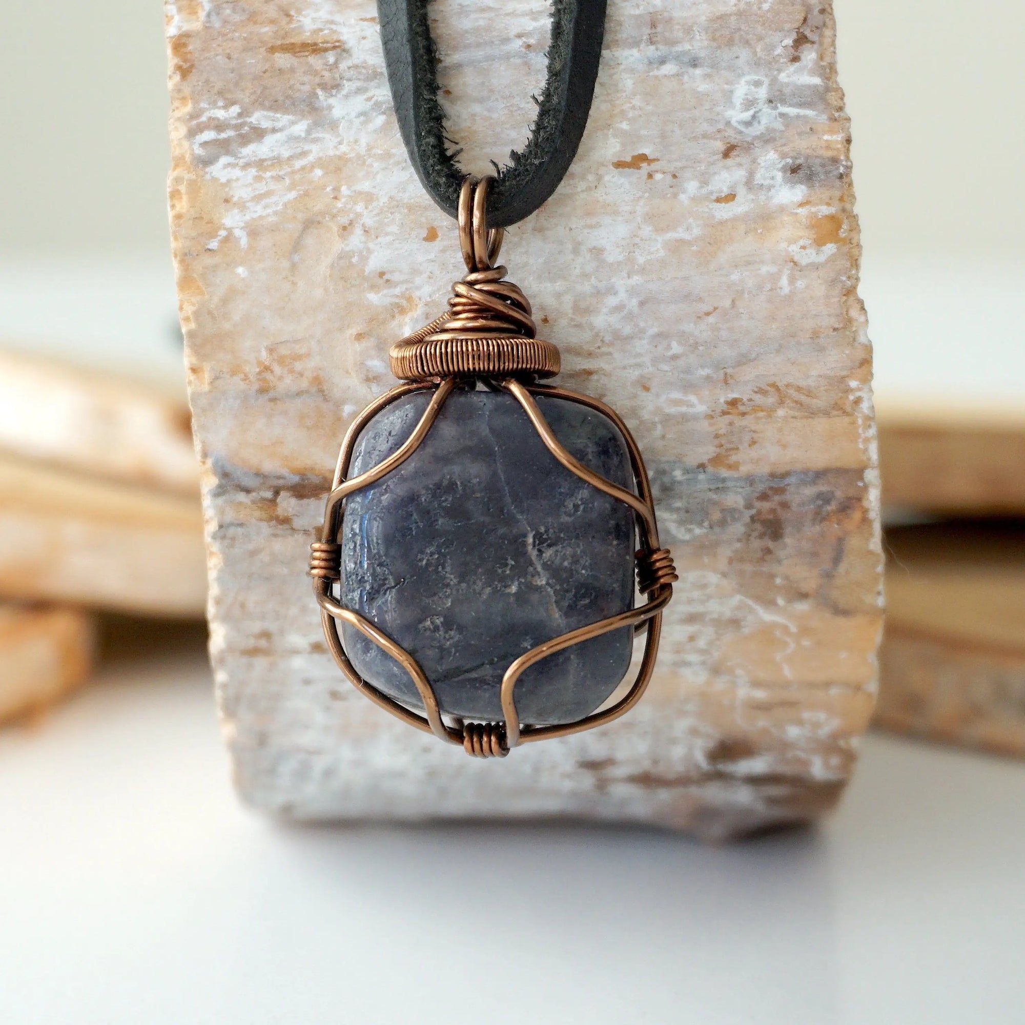 Handcrafted raw sapphire necklace for men, front view – artisan bronze copper wire wrapping, September birthstone, black leather cord.