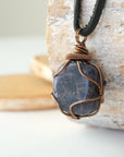 Left angle close-up of men's sapphire necklace – highlighting unique wire-wrapped artistry, genuine sapphire, black leather cord.