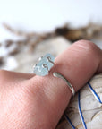 Adjustable aquamarine ring with raw gemstone in 925 sterling silver prong setting on female model's hand, Designs by Nature Gems