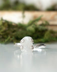 Close-up front view of raw rainbow moonstone stone in artisan 925 sterling silver adjustable ring setting, June birthstone ring.