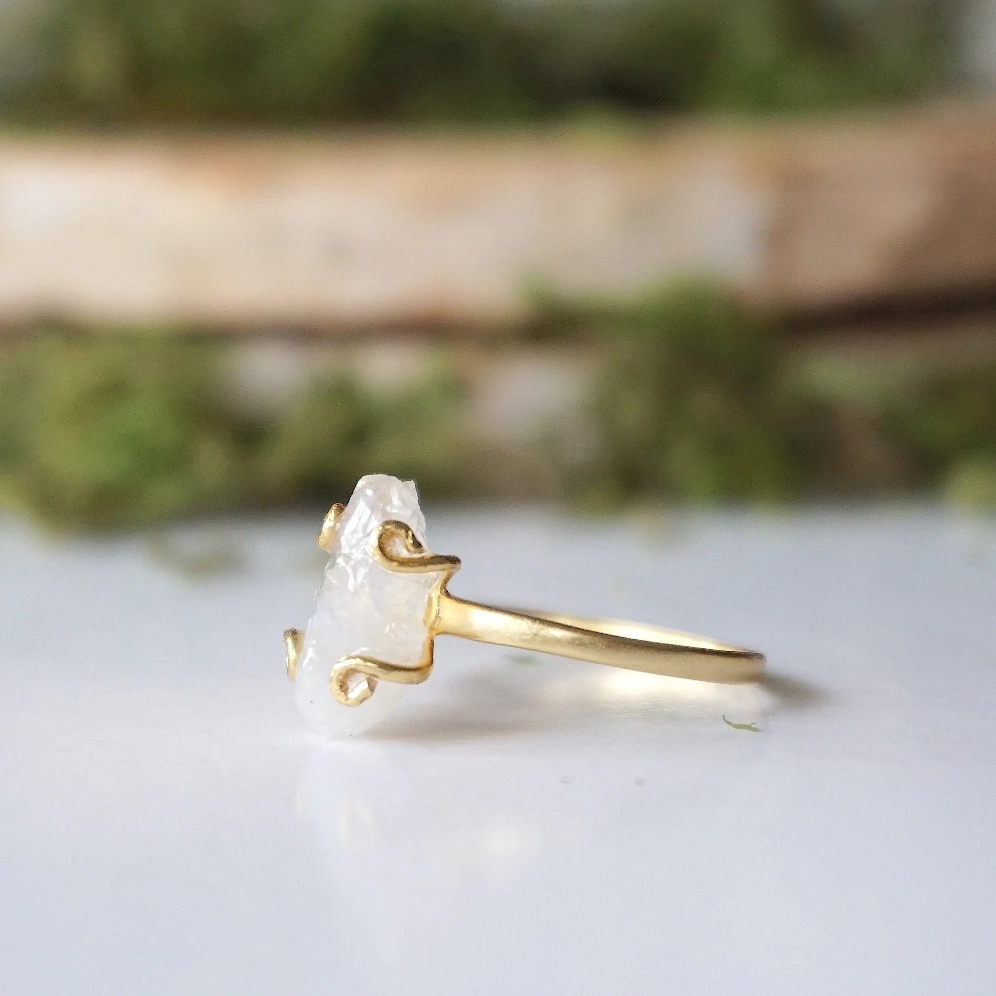 Left side angle close-up of adjustable raw rainbow moonstone ring highlighting organic moonstone profile and 14k gold vermeil setting.