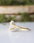 Left side angle close-up of adjustable raw rainbow moonstone ring highlighting organic moonstone profile and 14k gold vermeil setting.