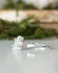 Left side angle close-up of adjustable raw rainbow moonstone ring highlighting organic moonstone profile and sterling silver setting.