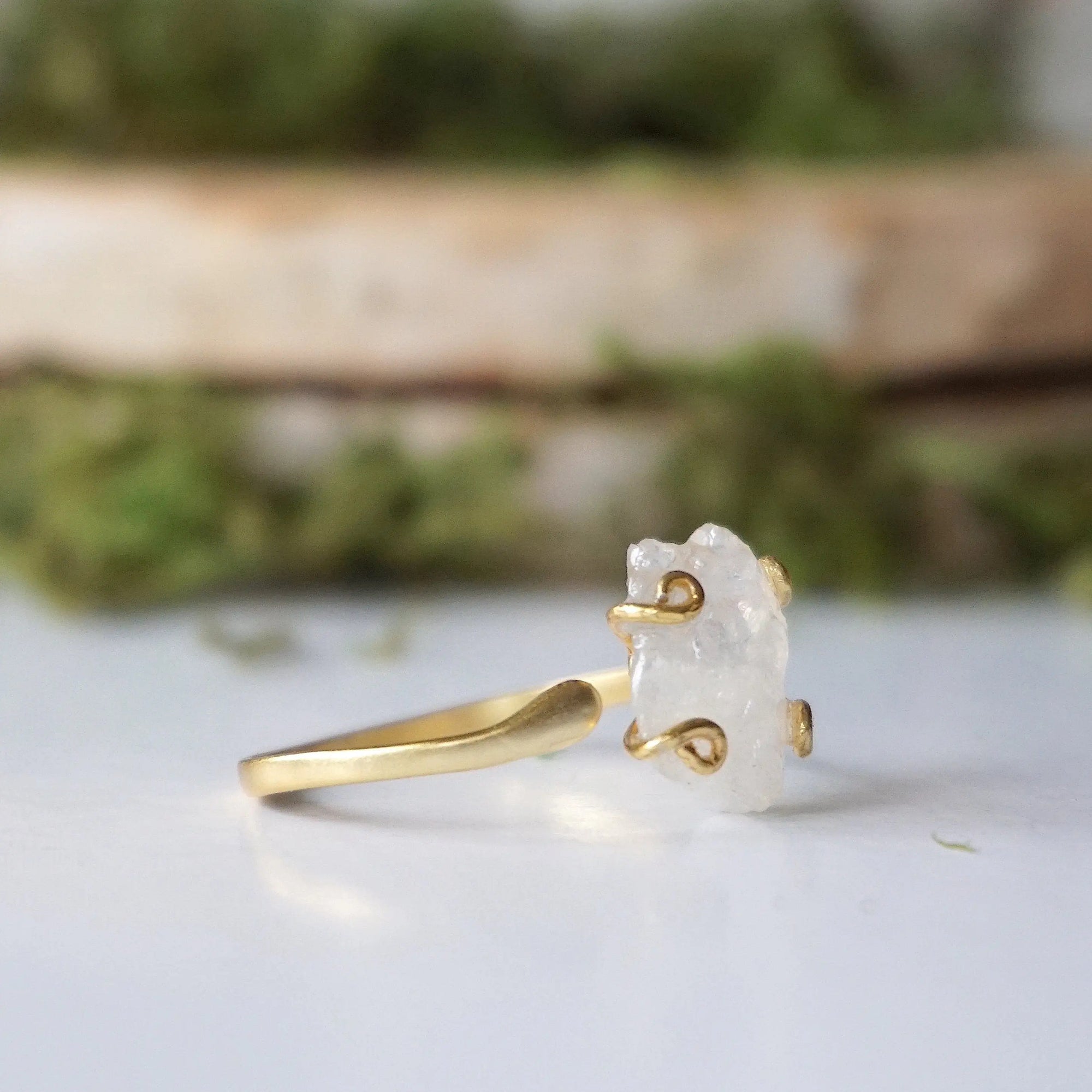 Right side angle close-up of adjustable raw rainbow moonstone ring showing gold vermeil prongs and natural stone shape.
