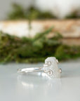 Right side angle close-up of adjustable raw rainbow moonstone ring showing sterling silver prongs and natural stone shape.