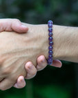 Amethyst beaded stretch bracelet on male model's wrist, natural 8mm amethyst beads, unisex style