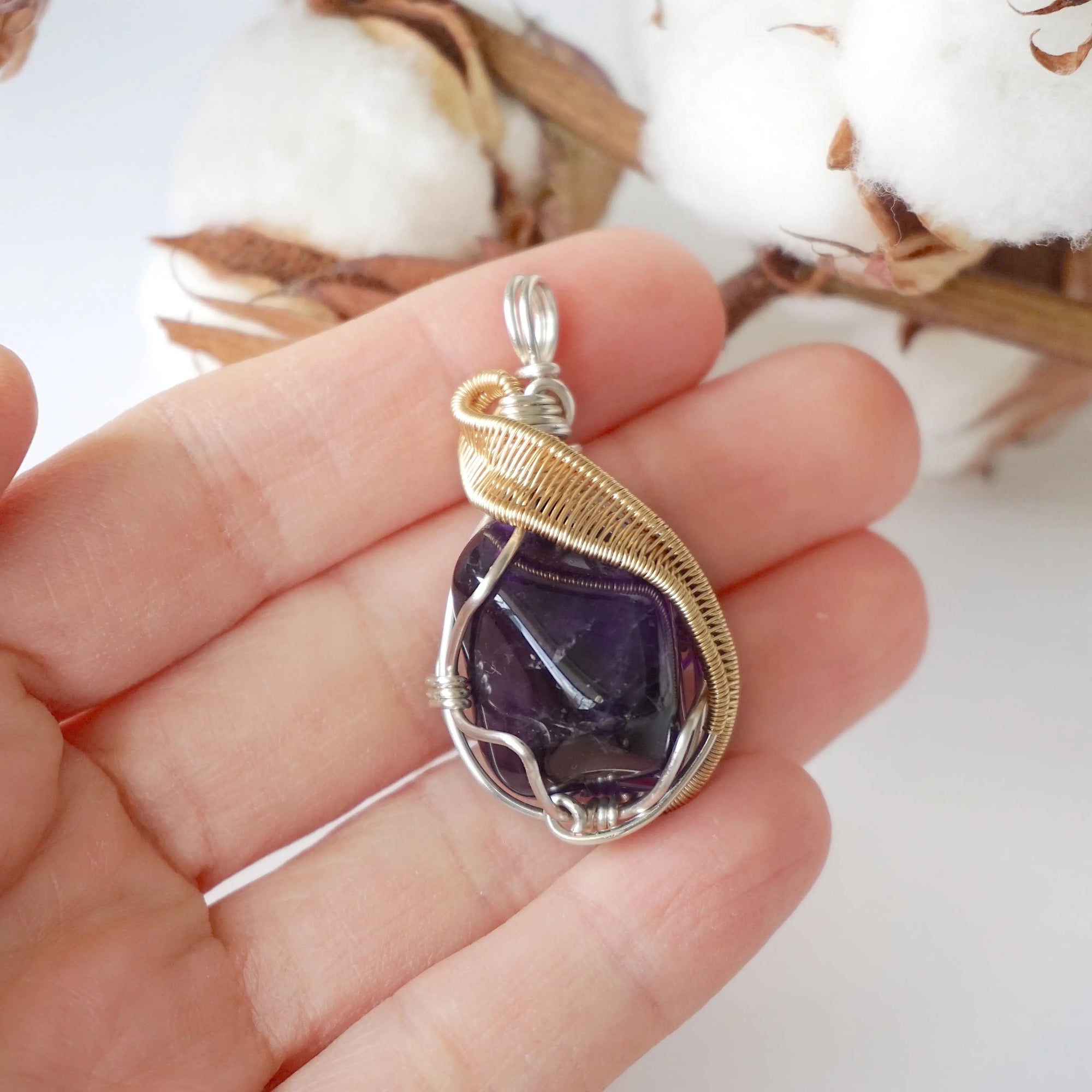 Amethyst necklace in hand for size reference, polished dark amethyst pendant, silver and gold plated copper artisan wire wrap