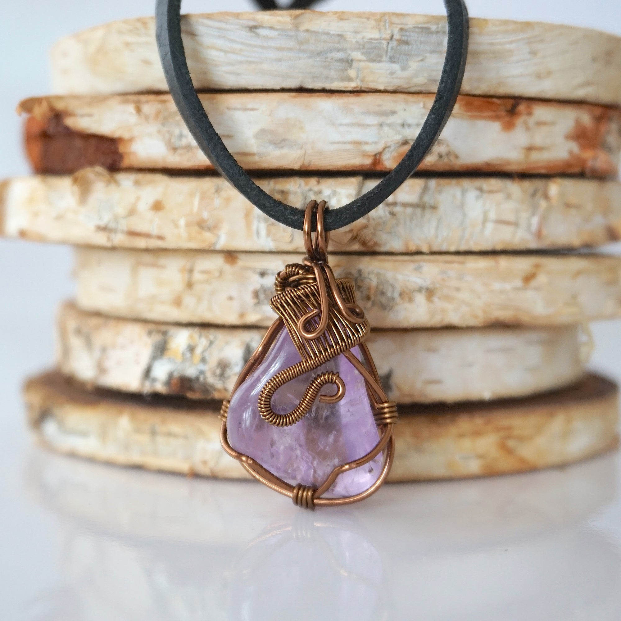 Back view of mens amethyst wire wrapped pendant — bronze copper finish hand-wrapped setting shows craftsmanship and secure stone hold, handmade in Toronto Canada