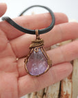 Handmade amethyst mens pendant held in hand showing size — natural polished-raw amethyst stone wire wrapped in bronze copper finish, 40-60 carats, one of a kind