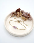 Handmade amethyst bracelet displayed on ceramic tray showing natural purple crystals and gold chain - February birthstone gift for her