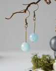 Side angle of minimalist aquamarine drop earrings on display, genuine 10mm aquamarine bead