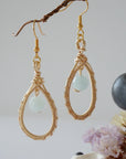 Another angle of aquamarine drop earrings highlighting detailed wire artistry and genuine aquamarine bead, warm gold finish