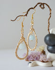 Side angle view of aquamarine drop earrings, showing intricate wire wrapping and warm gold finish, March birthstone