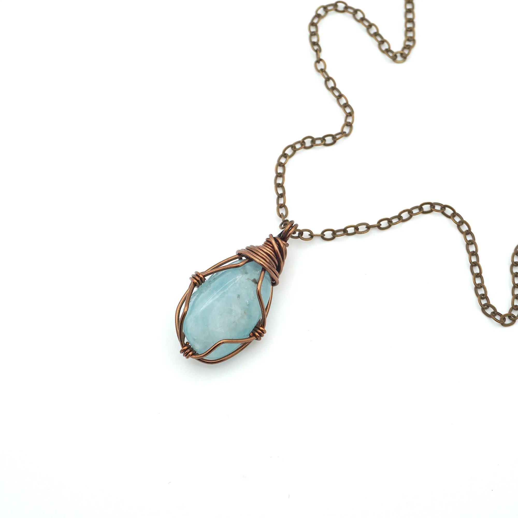 Genuine aquamarine necklace laying flat with antique bronze wire wrapping and chain, Designs by Nature Gems