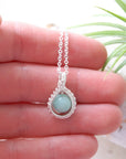 Aquamarine necklace in hand for size reference, genuine aquamarine bead, soft silver finish wire wrapping