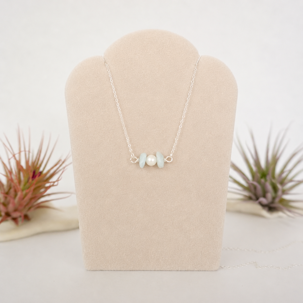 Aquamarine and freshwater pearl bar necklace in 925 sterling silver on jewelry display, front view