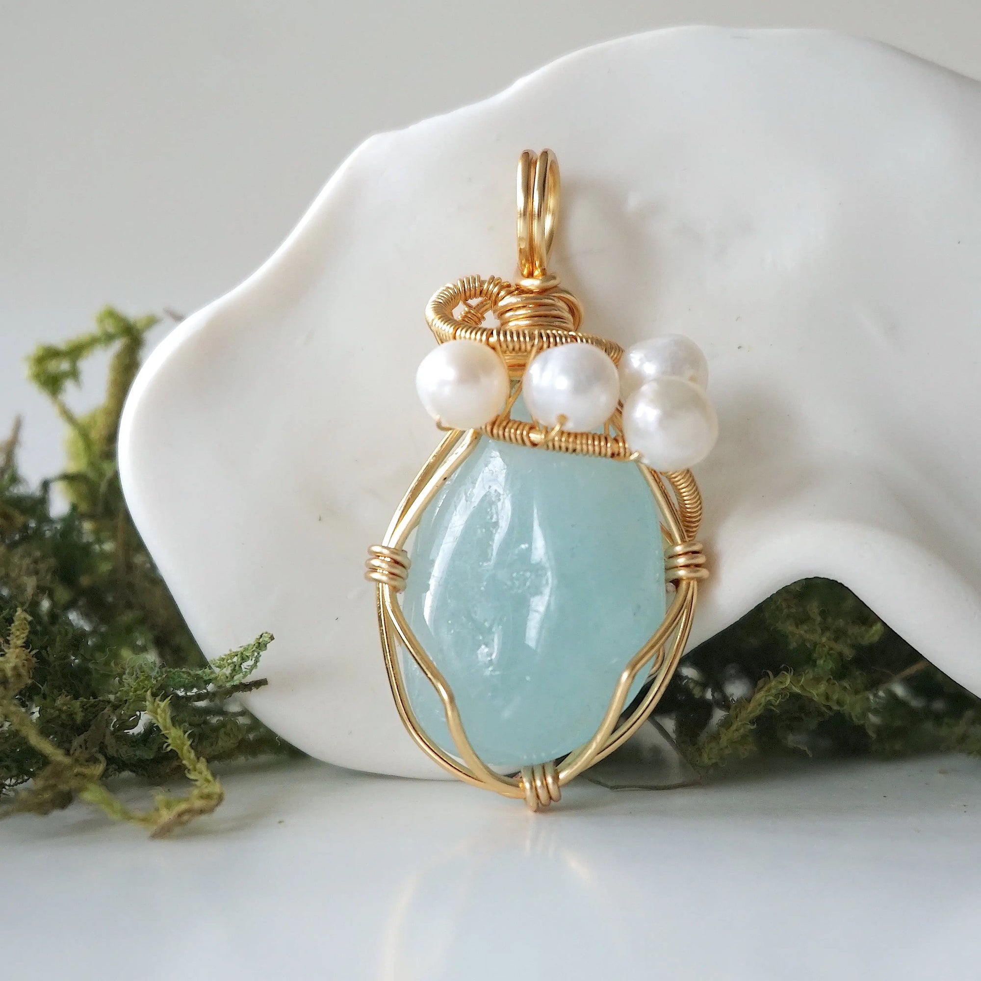 Detailed front angle of aquamarine and freshwater pearl pendant, gold wire wrapped, handcrafted gemstone jewelry