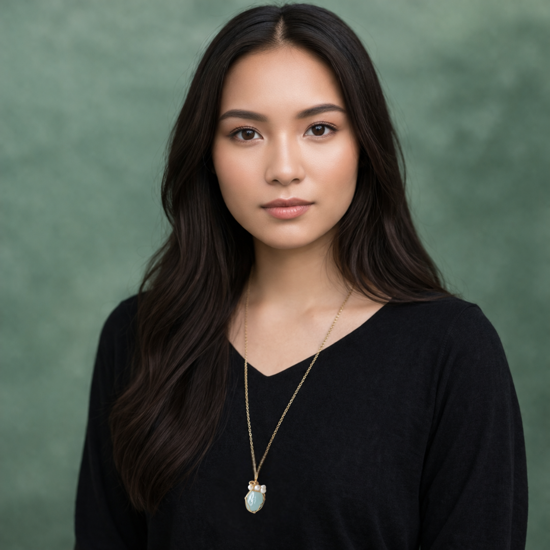 Model wearing aquamarine and freshwater pearl pendant on gold plated brass chain.