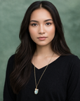 Model wearing aquamarine and freshwater pearl pendant on gold plated brass chain.