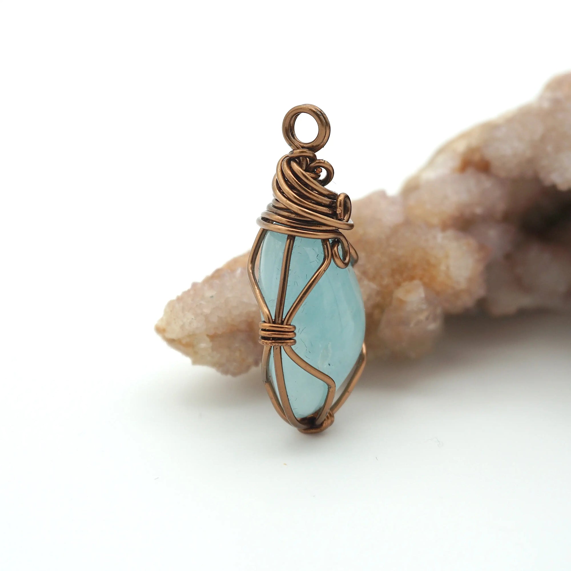 Side view of aquamarine pendant showing artisan wire wrapping and natural crystal shape, antique bronze finish