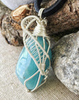 Side view of polished aquamarine pendant showing detailed artisan wire wrapping in sterling silver, men's design