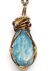 Back angle view of an aquamarine pendant necklace showing the wire wrapped design in antique bronze copper and brass