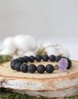 Right side angle of unisex black lava beaded bracelet featuring raw amethyst and pyrite accents