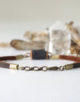 Lobster clasp and adjustable bronze chain extension on a men’s black tourmaline leather bracelet
