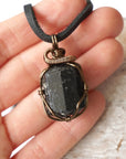 Raw black tourmaline necklace shown in hand for size reference, artisan jewelry by Designs by Nature Gems.