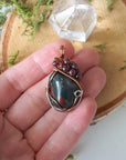 Bloodstone and garnet pendant necklace shown in hand for size reference