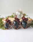 Three bloodstone and garnet pendants showing natural variation in size and stone shape