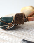 Close-up of artisan wire wrapping on natural bloodstone necklace, handcrafted by Designs by Nature Gems.