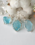 Three one-of-a-kind blue topaz pendants in sterling silver, showing how each stone differs