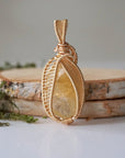 Close-up front view of polished citrine pendant gold wire wrapped November birthstone showing intricate detail
