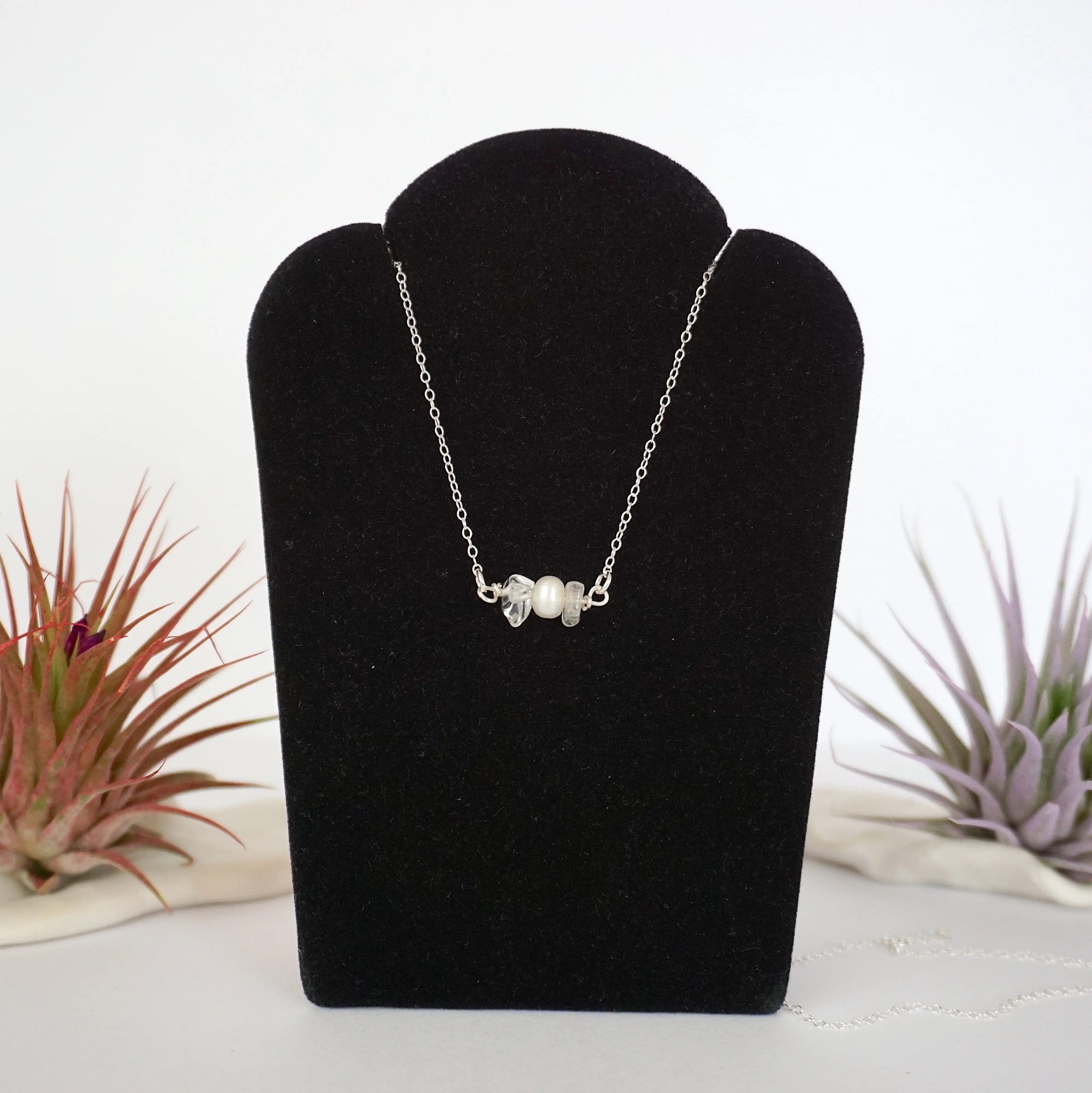 Clear quartz and freshwater pearl bar necklace in 925 sterling silver on jewelry display, front view