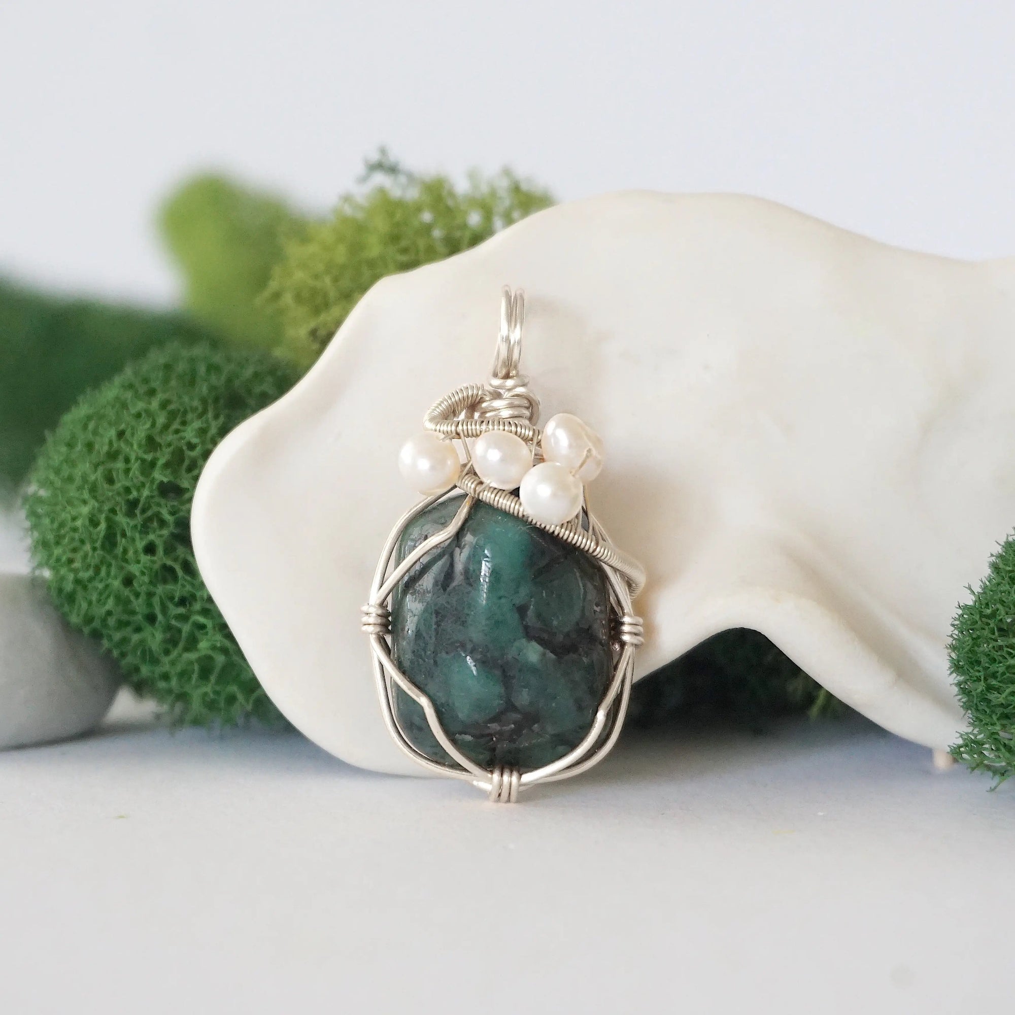 Detailed front view of silver wire wrapped emerald and freshwater pearl pendant, unique artisan necklace