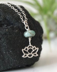 Right angle detail of emerald and lotus necklace for women with faceted emerald bead and artisan sterling silver lotus design