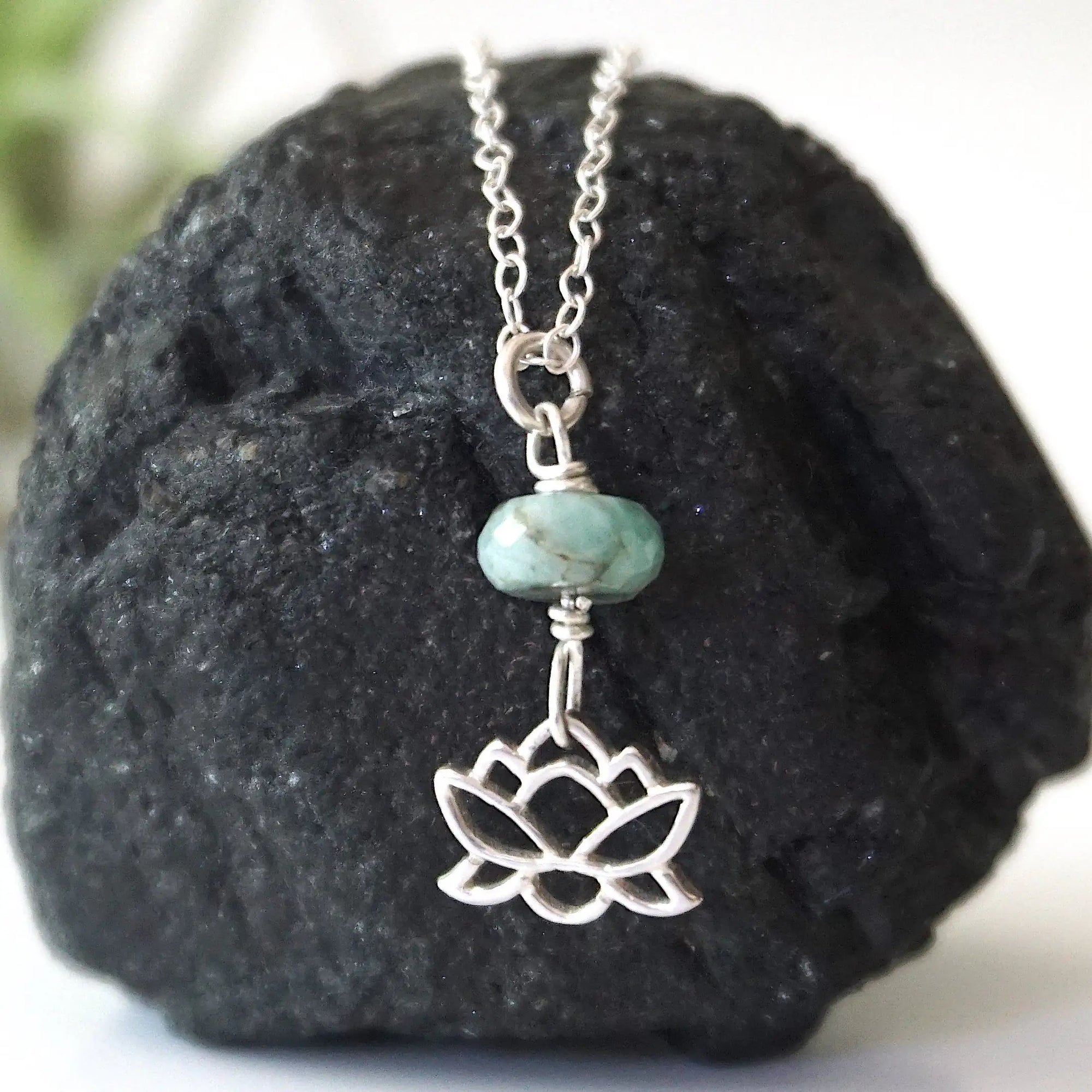 Emerald and lotus necklace for women with natural faceted emerald bead and sterling silver lotus charm, detailed front view