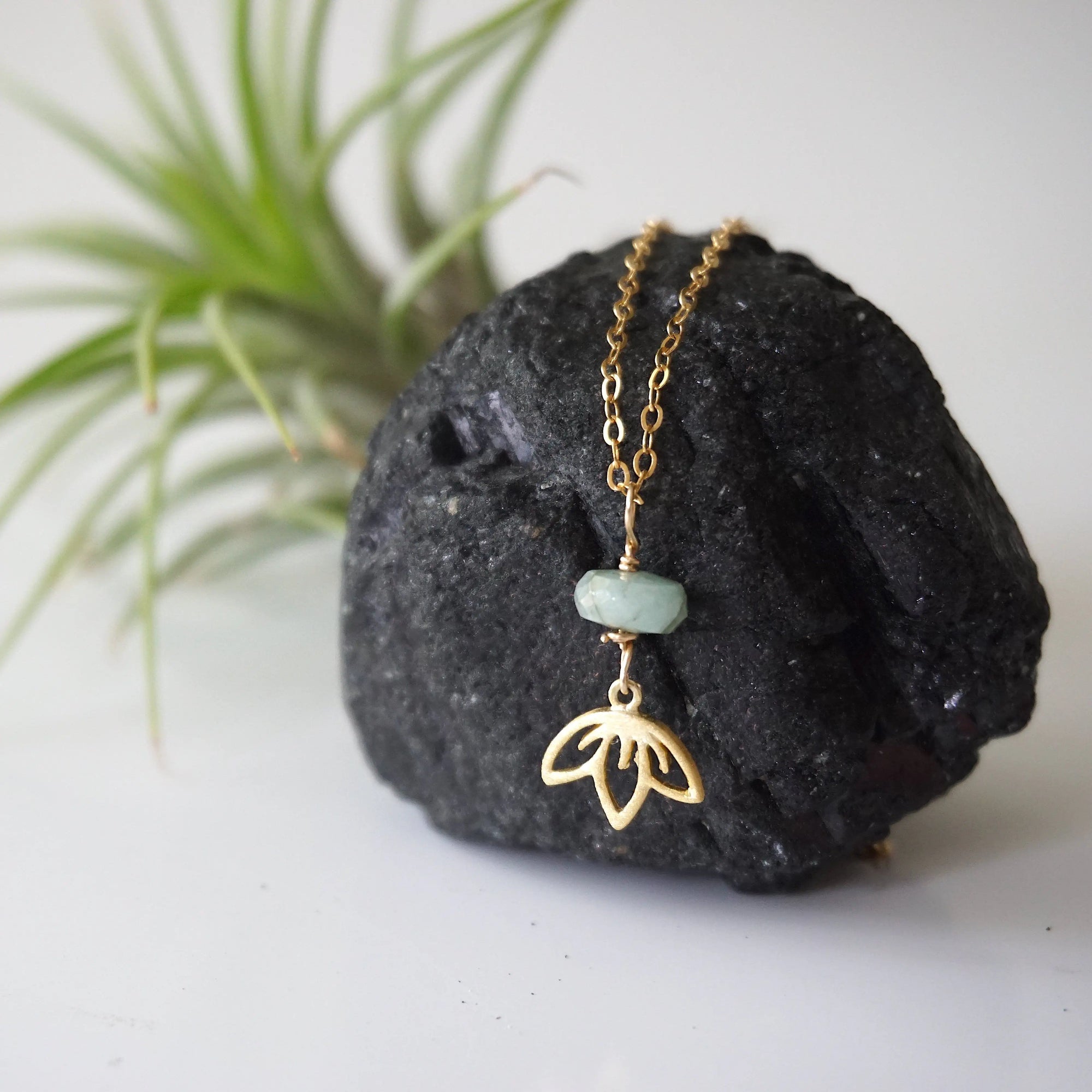 Zoomed out view of emerald and lotus necklace for women with gold vermeil lotus charm on fine chain