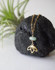 Zoomed out view of emerald and lotus necklace for women with gold vermeil lotus charm on fine chain