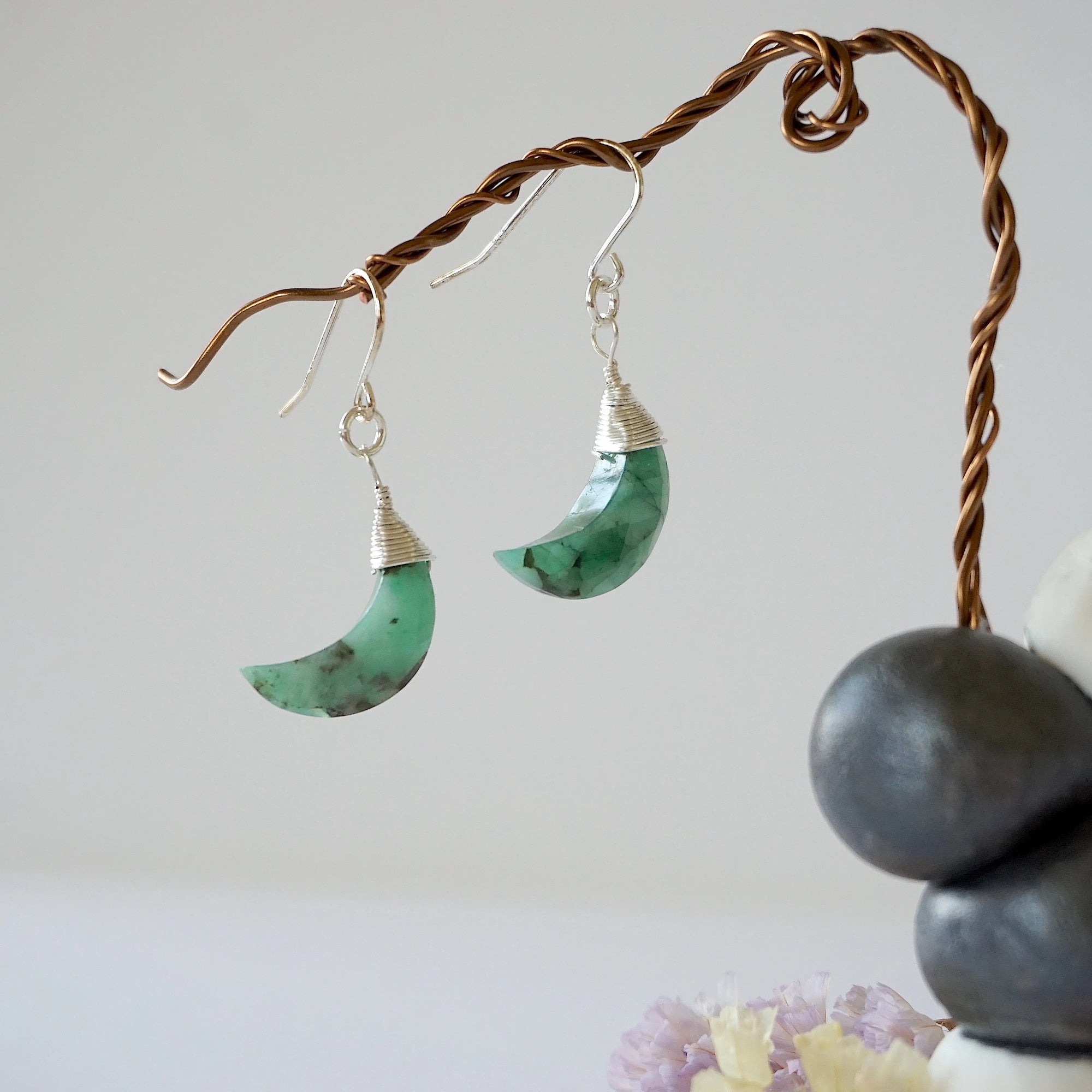 Front view of emerald moon drop earrings in 925 sterling silver with natural faceted crescent moon emeralds.