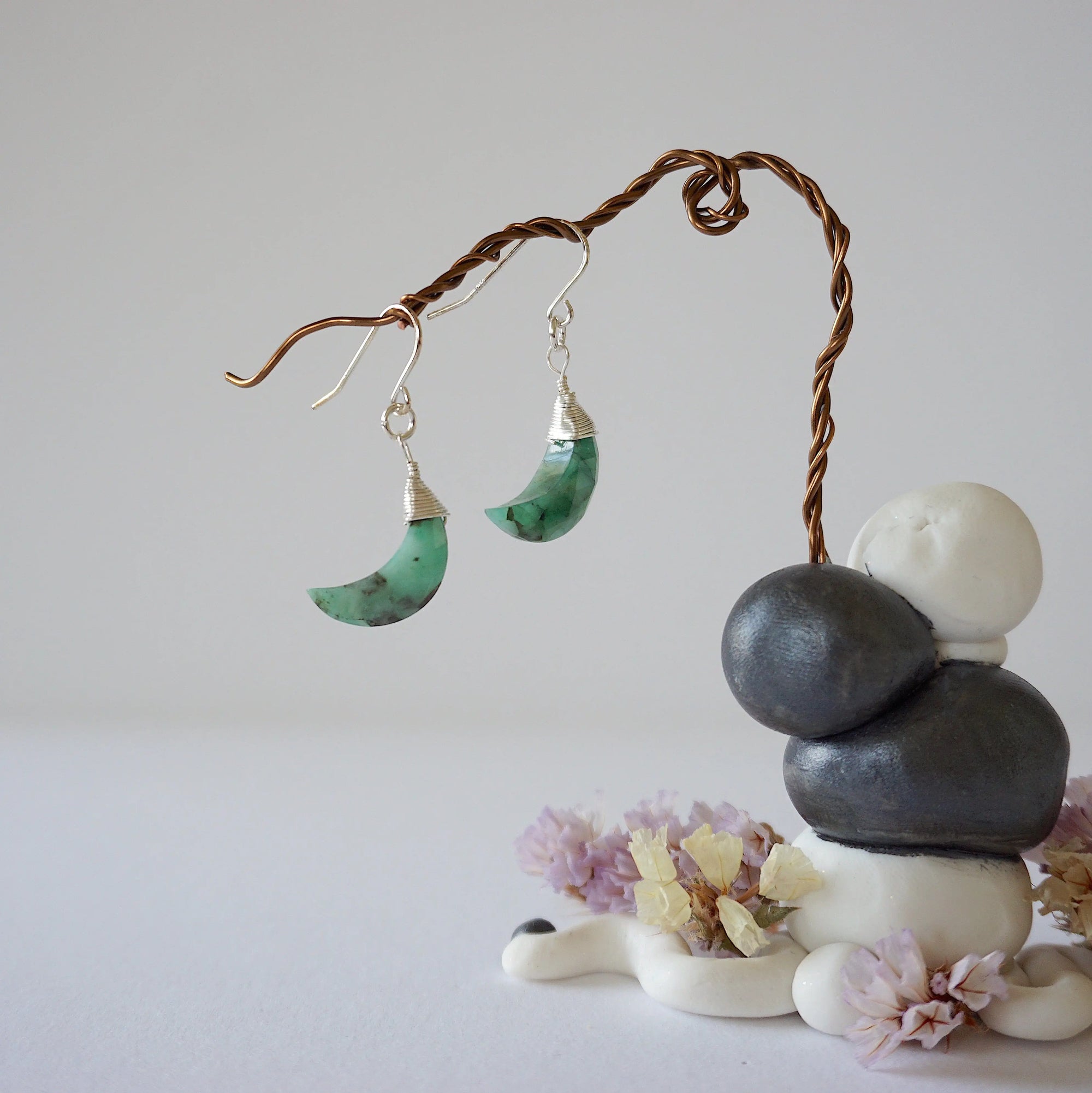 Zoomed out front view of emerald moon drop earrings in sterling silver with natural faceted emerald stones.