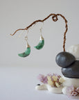 Zoomed out front view of emerald moon drop earrings in sterling silver with natural faceted emerald stones.