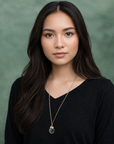 Model wearing emerald and freshwater pearl pendant on gold plated brass chain.